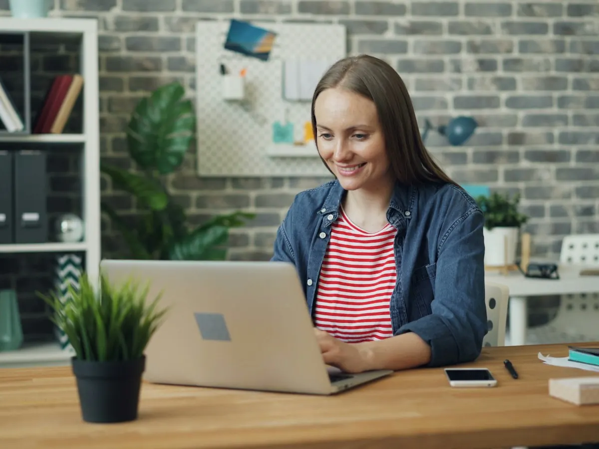 Colaboradora num escritório a trabalhar no computador portátil